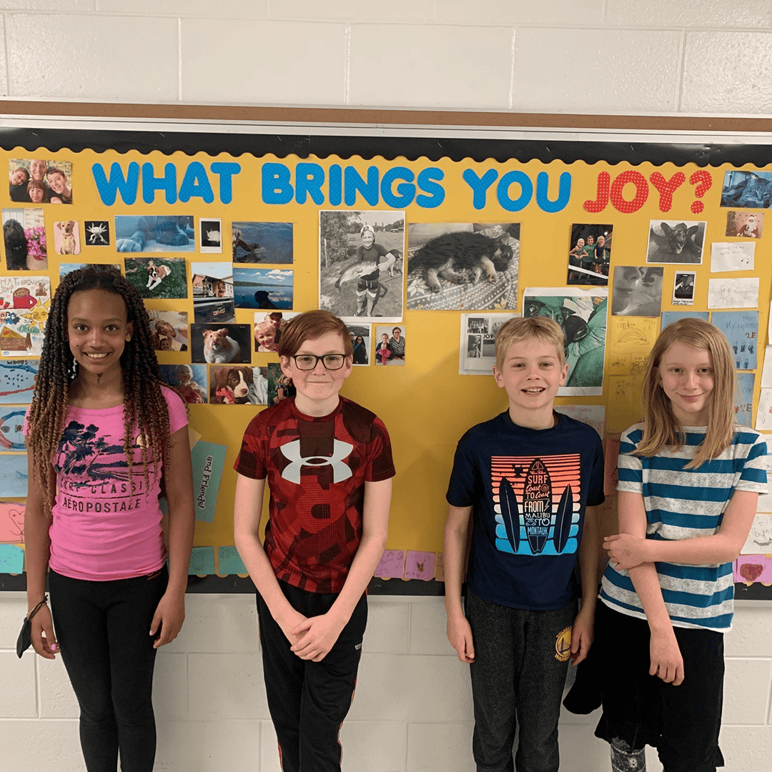 Lockview Public School students standing in front of their 'What brings you joy?' bulletin board.