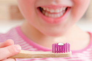 Showing the size of a pea on a toothbrush