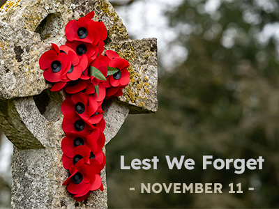 A cross with red poppies and text that says Lest We Forget, November 11