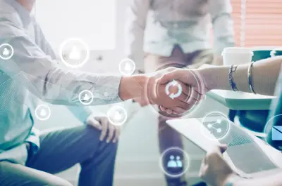 Business people shaking hands with an overlay of icons highlighting business processes