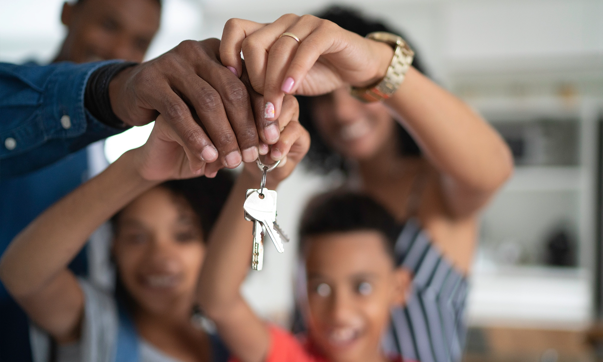 young family holding keys to their home