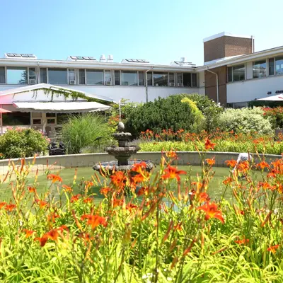 The exterior of Linhaven Long-Term Care home, featuring a fountain and a garden