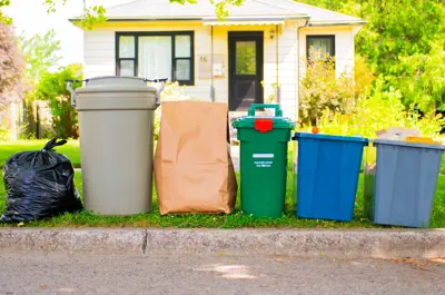 Garbage, organics and recycling set out curbside in front of a house