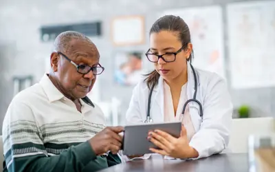 Health care professional looking at a table with an older adult