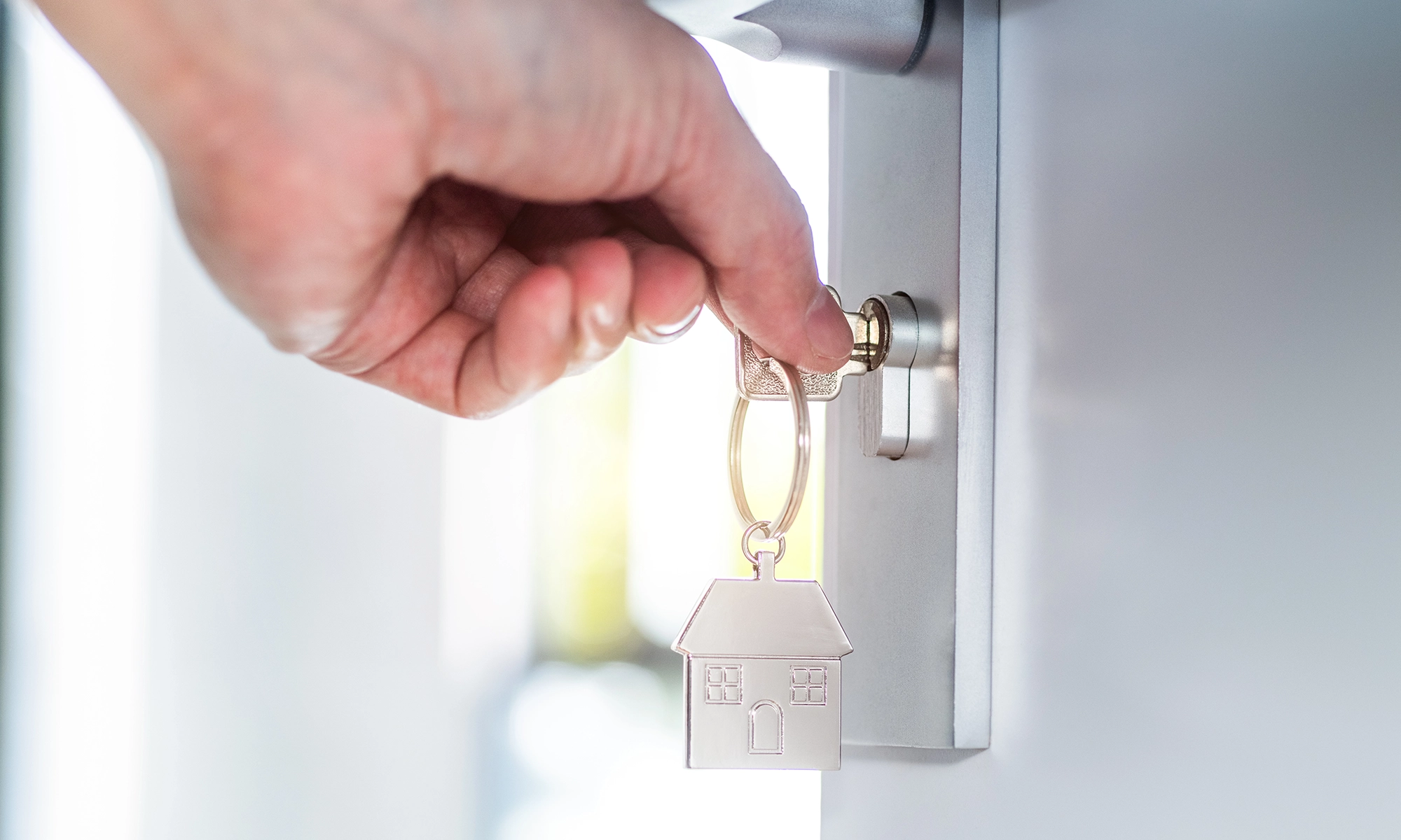 Close up of a hand inserting a key into a door.