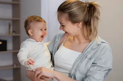 A young mother holds a smiling baby