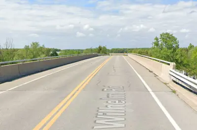A screenshot from Google Street View shows the Wilhelm Road Bridge surrounded by trees