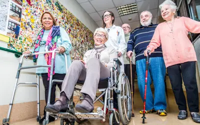 Group of older adults using various mobility devices to walk.