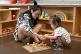 Woman and child playing with blocks at an EarlyON Centre