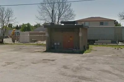 The Arena Sewage Pumping Station Upgrades is a small brown building with a red door