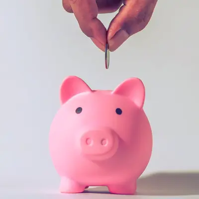 Coin being put into a piggy bank