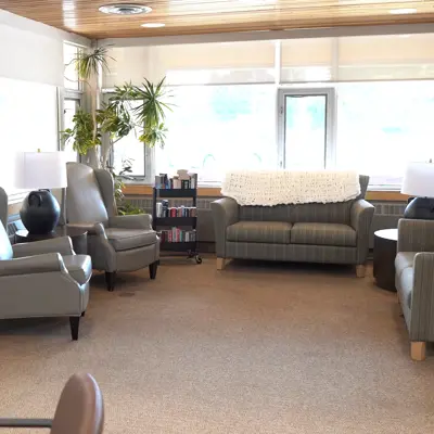 A recreation area at Rapelje Lodge with couches and a bookshelf and table