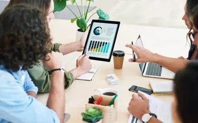 People reviewing pie charts and graphs on a tablet together