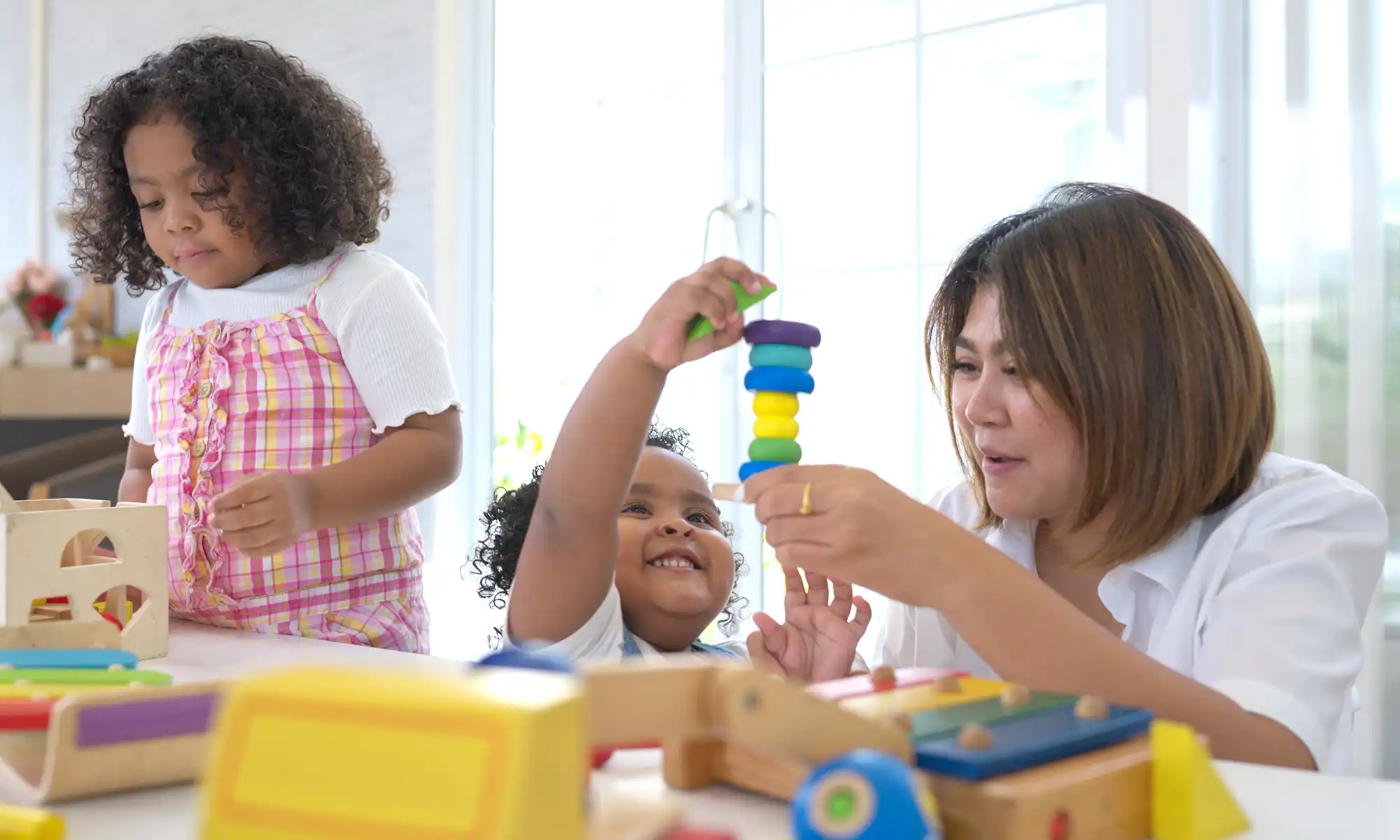 A home child care providers cares and plays with two children in her home.