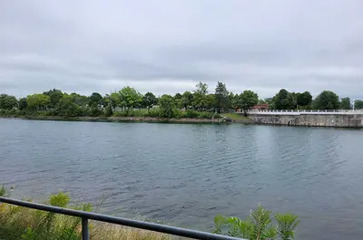 The Welland Recreational Canal is surrounded by grass and trees and separated from land by a guardrail